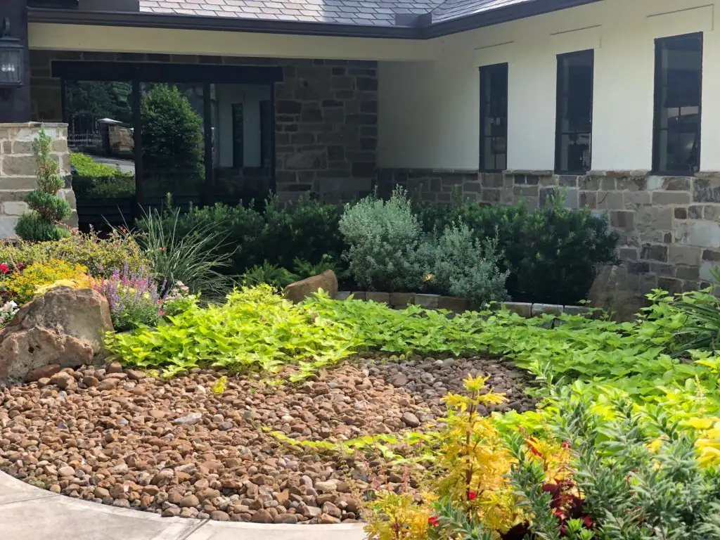Commercial landscape with stone, plantings, and dry creek